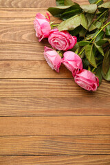 Beautiful pink roses on wooden background