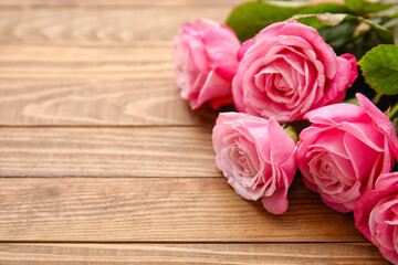 Beautiful pink roses on wooden background