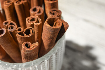 Cinnamon sticks in cup on table, closeup