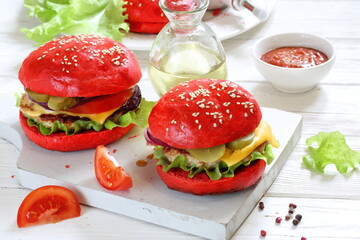 Burgers with red buns and chicken cutlet on a white plate