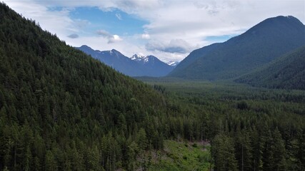 Forested valley with mountains surrounding and in the distance