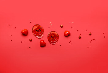 Glasses of wine and hearts on color background. Valentine's Day celebration