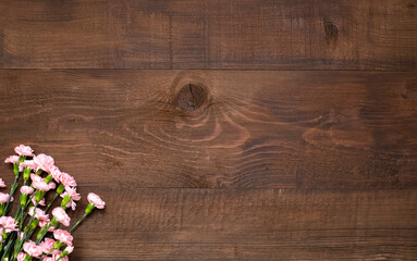 .Pink flowers on dark brown wooden table with copy space.