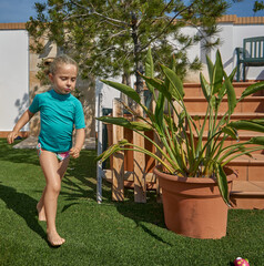 Ni&ntilde;a rubia corriendo en el jard&iacute;n en verano
