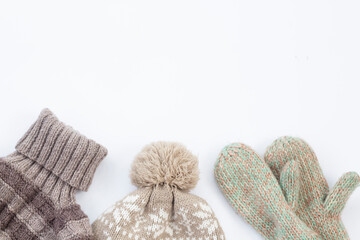 A set of fashionable winter clothes Knitted sweater hat and gloves on white background with copy space