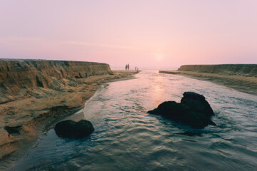 Sunset over the Arabian Sea and tidal river flowing inland. Kannur, India.