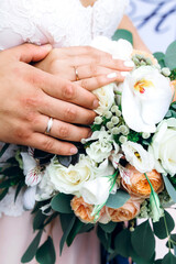 Wedding bouquet with hands and wedding rings