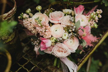 Beautiful modern bridal bouquet of colorful fresh flowers and greenery with silk ribbons. Classic wedding traditional accessory.