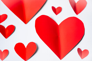 Paper elements in shape of heart flying on white background. Symbols of love for Happy Women's, Mother's, Valentine's Day, birthday greeting card design.