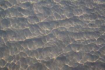 optics of water. Glare in the sand on the beach at the sea