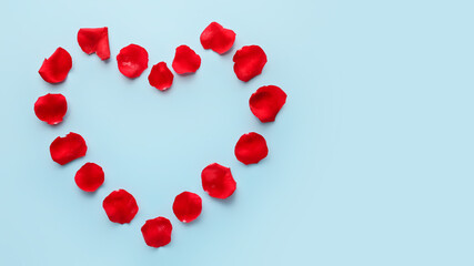 Heart made of beautiful rose petals on color background