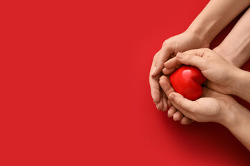 Hands with red heart on color background