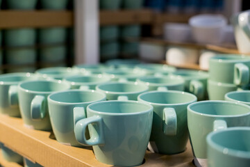 Background of empty ceramic cups.White and blue cups on the shelves in the store.concept of coffee addiction and crockery products.Stack of clean mint cups in cafe or restaurant