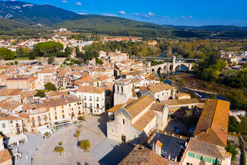 Fototapeta na wymiar Aerial view of historic centre of Besalu with Romanesque bridge over Fluvia river in sunny fall day, Catalonia, Spain