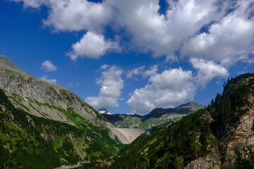 dam wall in a mountain valley with beautiful sky