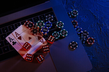 Casino play online concept. Playing chips, cards and dices on laptop's keyboard.