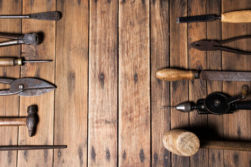 Old carpenter hand tools on weathered wooden plank background