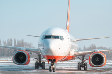Modern passenger airplane on the apron of airport during taxiing. Winter taxi on apron. Snow blizzard. Airport in snow.