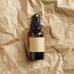 Amber glass spray bottle with blank label on crumpled paper. Top view, flat lay. Natural cosmetics packaging design