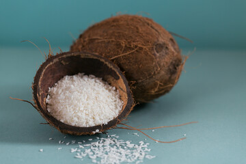 Whole coconut with coconuts flakes on a blue background