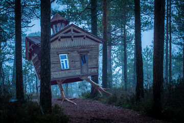 Baba Yaga witch house standing on chicken legs and walking in a night forest between trees
