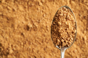 Panela or rapadura - healthy sweetener made by evaporating sugercane juice, on a metal spoon with...