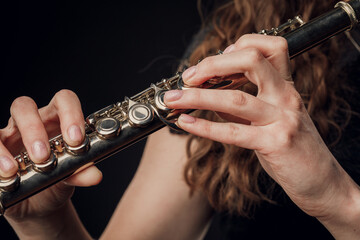 Close-up of the hands of a woman playing the flute. Musical concept.