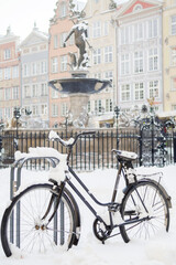 Ośnieżony rower przy pomniku Neptuna w Gdańsku