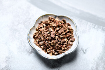 Dry root of Rhodiola rosea. Golden root, rose root. Healthy medical plant on wooden background. Close up.