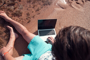 freelancer with a laptop works on a beach