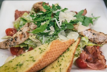 Caesar salad a green salad of romaine lettuce and croutons dressed with lemon juice olive oil, parmesan cheese and chicken. Also called Cesare salad