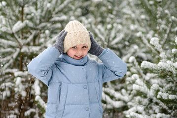 Happy little girl in beautiful winter snow forest. Walking and active rest