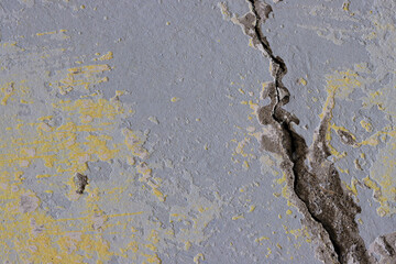 Vintage wall texture. Weathered rough surface of a plastered concrete wall with a crack and faded paint. Perfect for background and design. Closeup. High resolution.