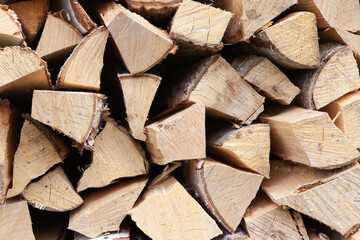Background from stack of firewood from birch tree, for heating house, stacked in backyard, uncut wood, birch. Concept eco-friendly home heating during cold season. Overall plan. Horizontal format