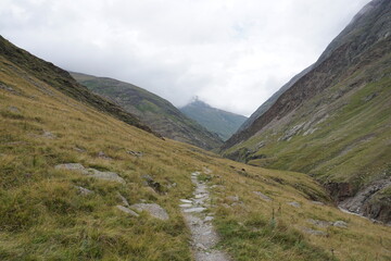 Fototapeta na wymiar schmaler Wanderweg bergab ins Tal
