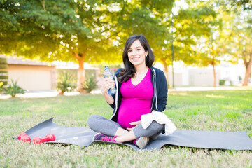 Portrait of a sporty pregnant woman drinking water