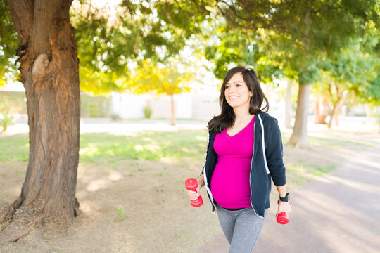 Active Pregnant Woman Exercising In The Park