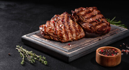 Fresh juicy delicious beef steak on a dark background
