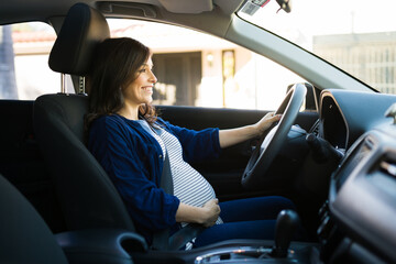 Fototapeta na wymiar Happy pregnant woman driving to her house