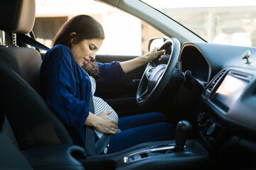 Pregntant woman with cramps while driving her car