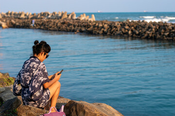 young woman enjoying on the river bank with the sea in the background