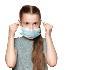 Beautiful teen girl with long hair puts down medical mask from face and looks at the camera