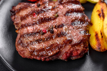 Fresh juicy delicious beef steak on a dark background