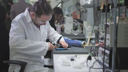 Production of a prosthetic hand. A scientist engineer creates or diagnoses a robotic arm prosthesis. Prosthetic laboratory. A mechanical arm for a fulfilling life. Creation of cybernetic limbs. - Powered by Adobe