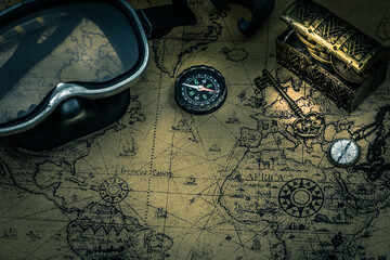 Old map with diving equipment. A treasure chest, a compass and a key, Scuba travel concept.