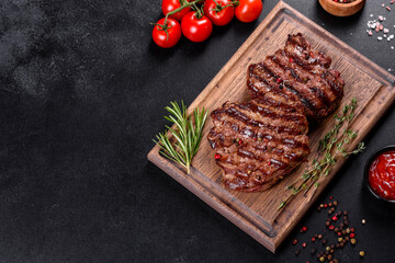 Fresh juicy delicious beef steak on a dark background