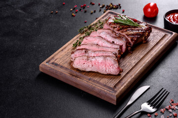 Fresh juicy delicious beef steak on a dark background