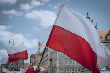 The Polish flag waving over the crowd of people 