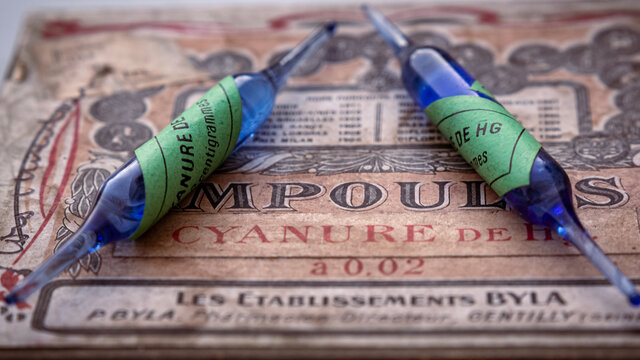 close-up of old blue cyanide ampoules with green stickers on an old pharmaceutical box. translation : hg cyanide ampoules. retro style. former pharmaceutical drugs