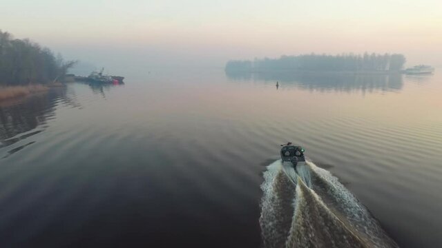 Fast fshing motor boat runs ahead. Drone footage